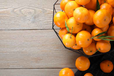 Photo of Fresh ripe tangerines on wooden table, flat lay. Space for text