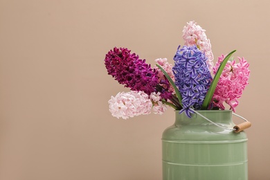 Beautiful hyacinths in metal can on color background, space for text. Spring flowers