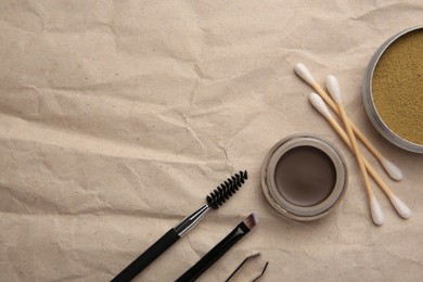 Photo of Flat lay composition with eyebrow henna and tools on crumpled paper. Space for text