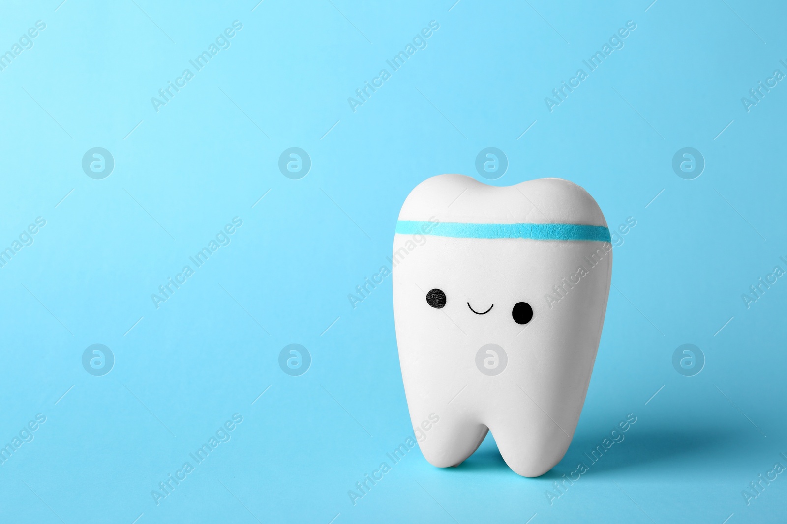 Photo of Model of tooth with happy face and space for text on color background