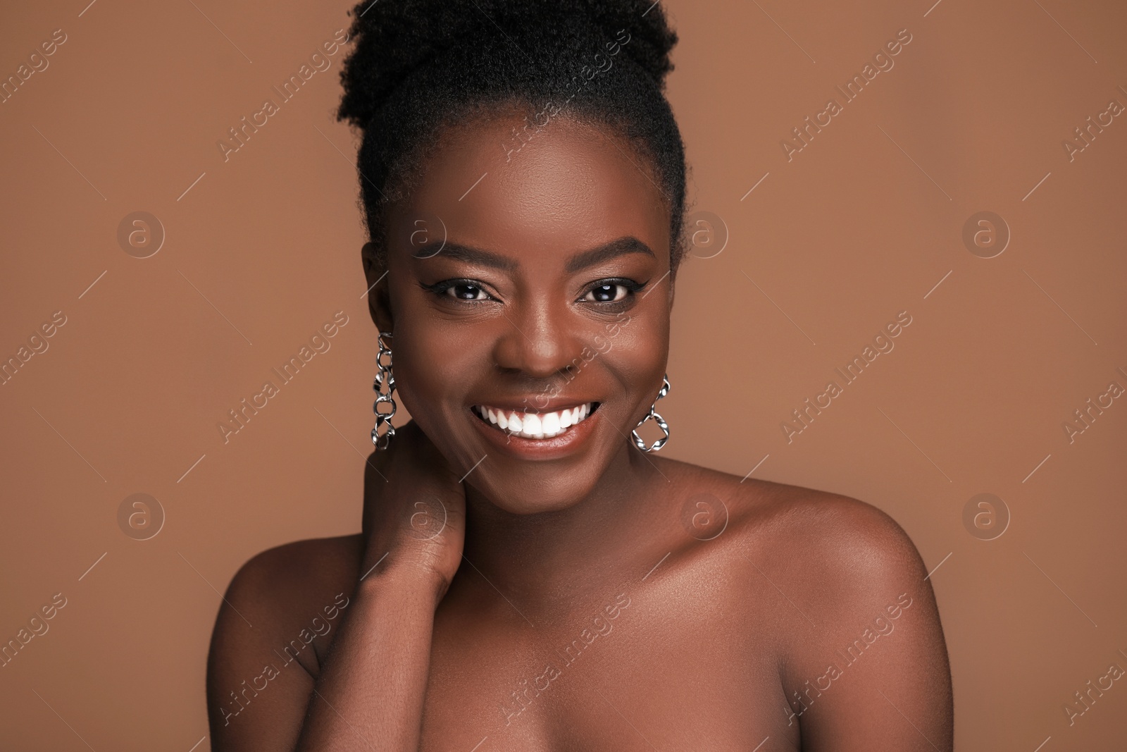 Photo of Fashionable portrait of beautiful happy woman on light brown background