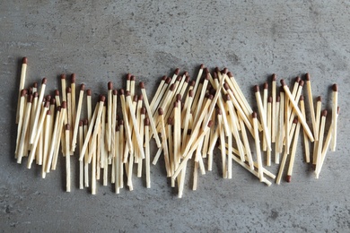 Photo of Many matches on grey background, top view