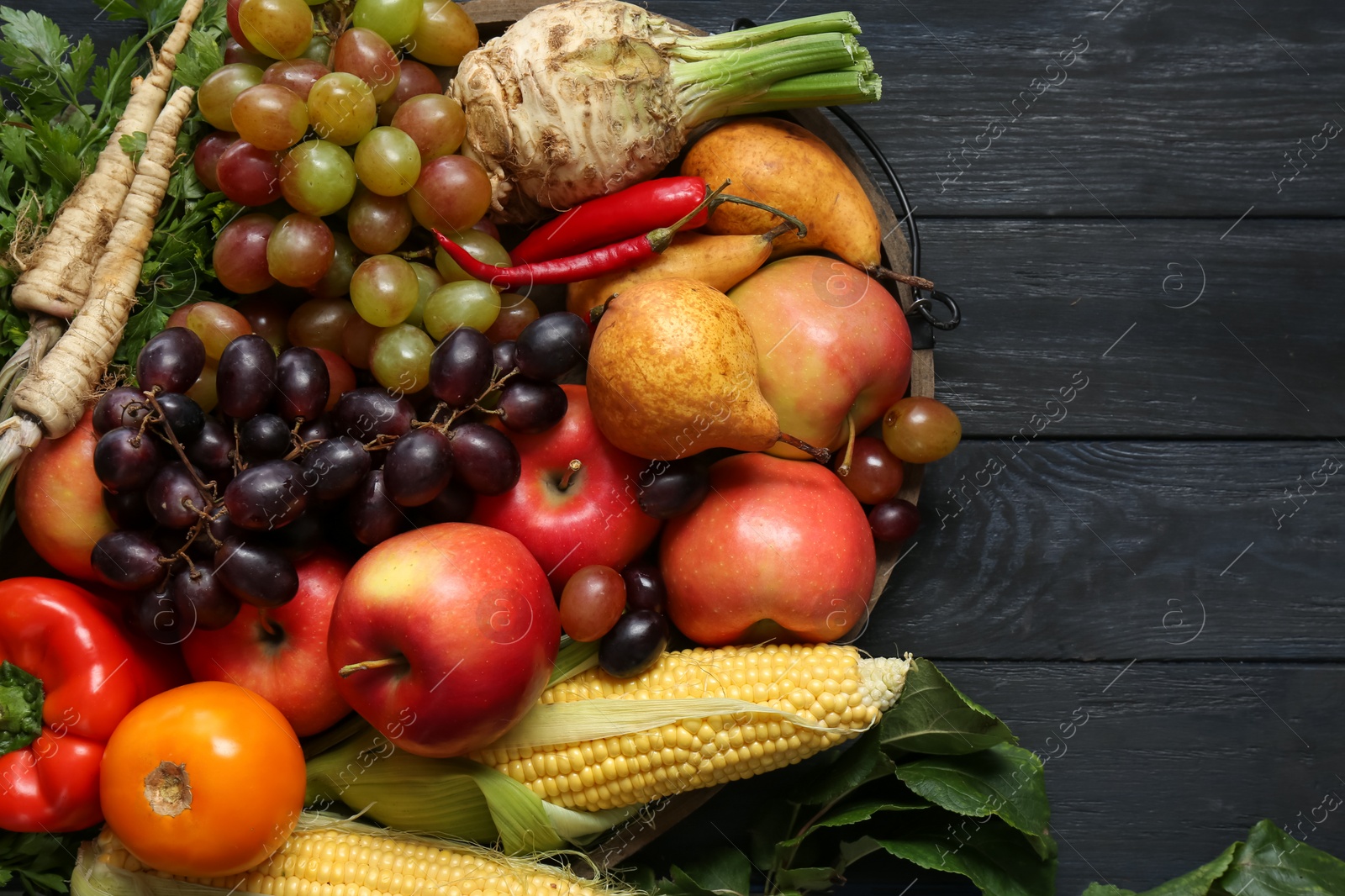 Photo of Different fresh vegetables and fruits on black wooden table, top view. Farmer harvesting