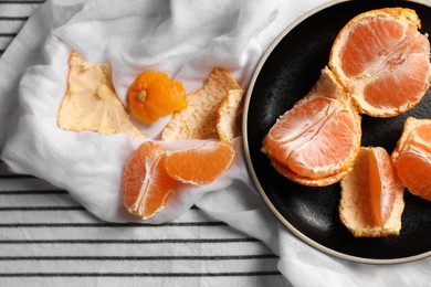 Fresh ripe tangerines on striped cloth, flat lay. Space for text