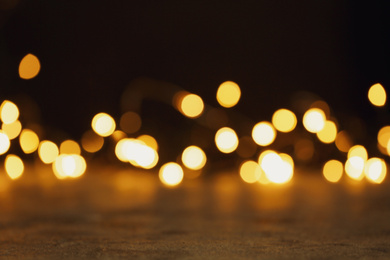 Photo of Stone table and festive lights. Bokeh effect