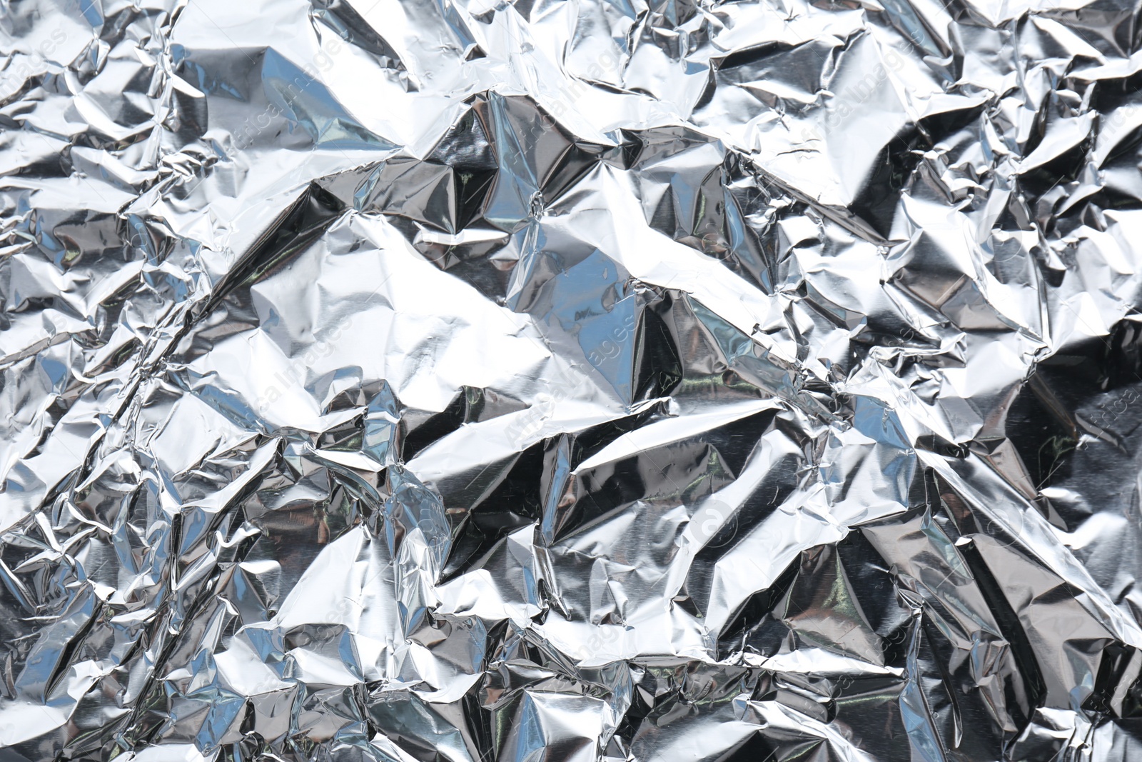 Photo of Crumpled silver foil as background, closeup view