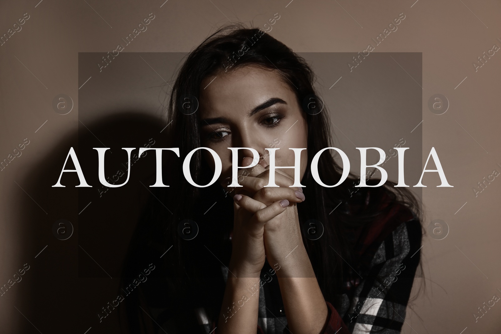 Image of Depressed young woman near brown wall. Autophobia - fear of isolation