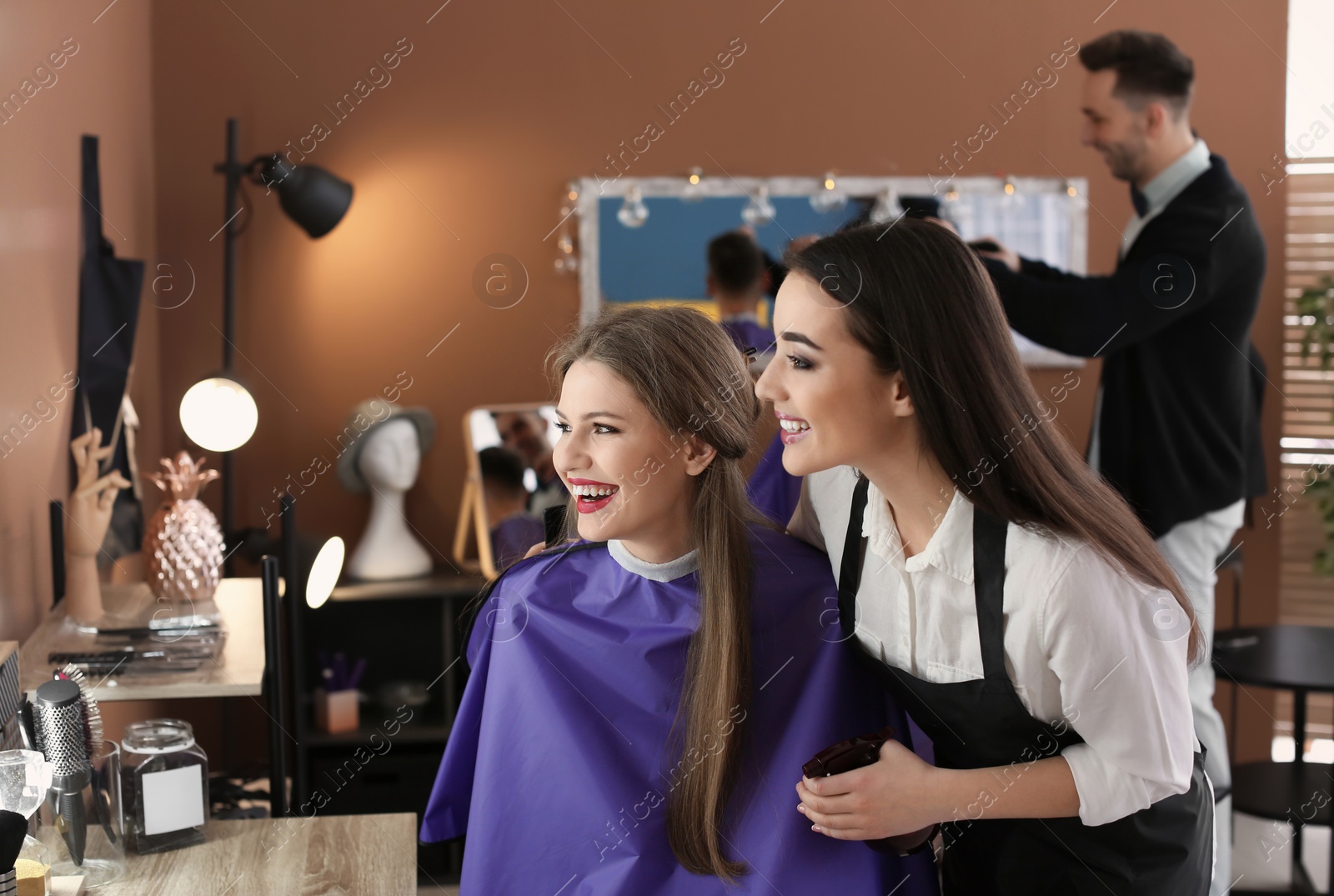 Photo of Hairdresser with happy client in beauty salon