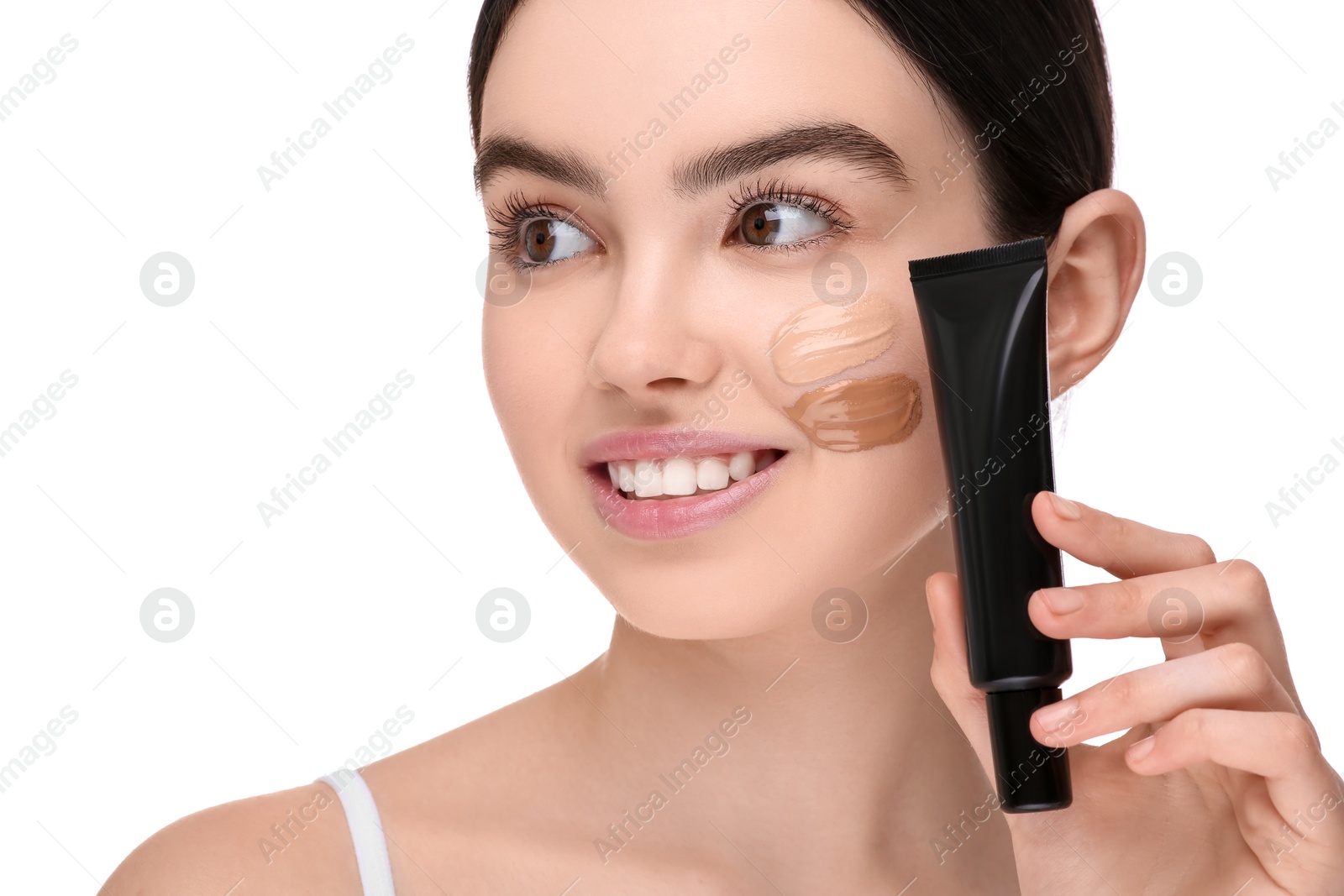 Photo of Teenage girl holding tube of foundation on white background