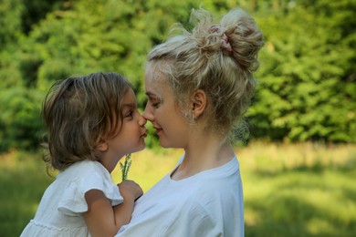 Portrait of beautiful mother with her cute daughter outdoors