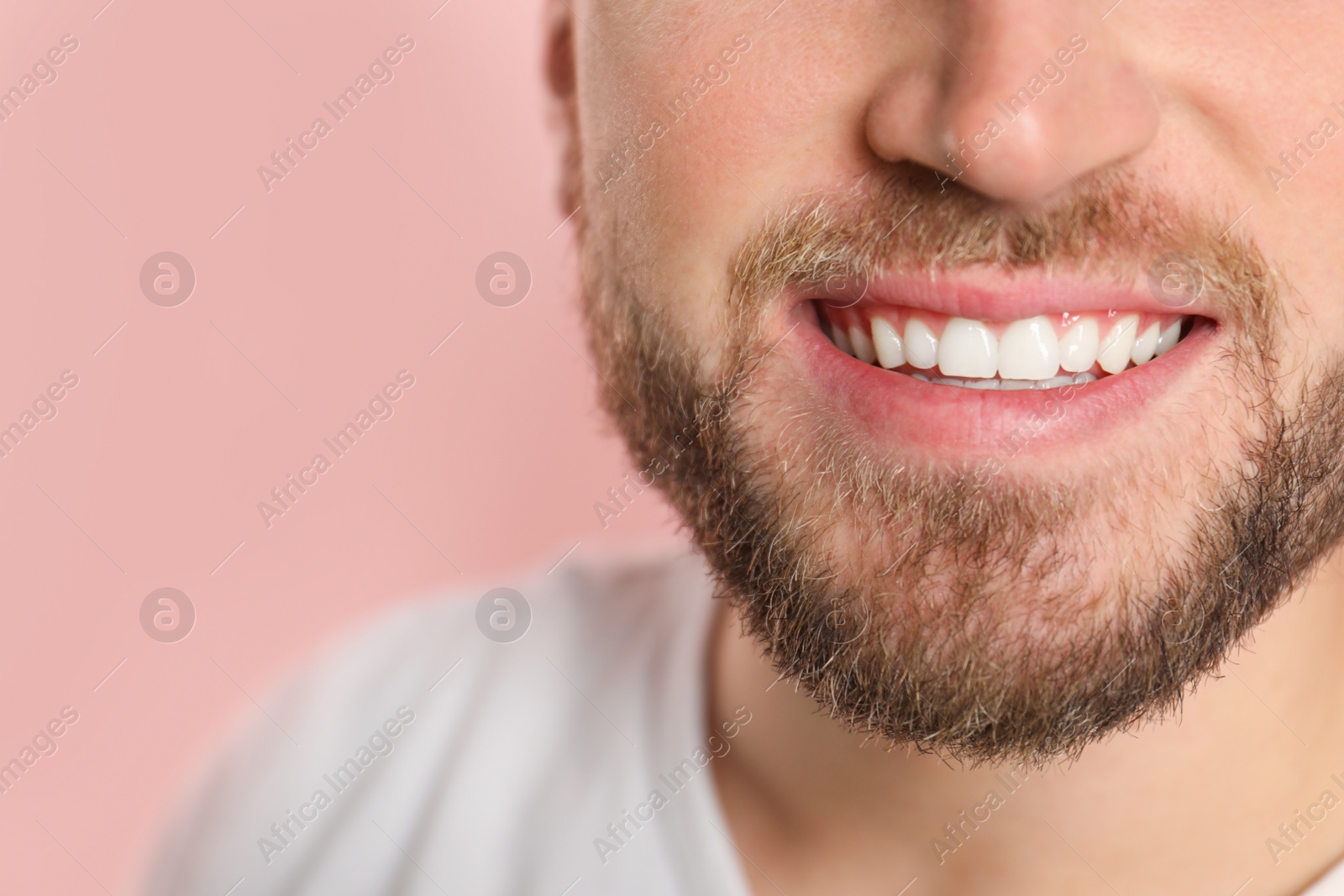 Photo of Young man with healthy teeth on color background, closeup. Space for text