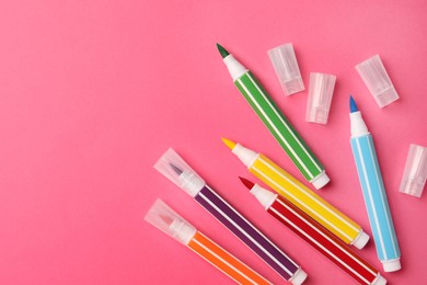 Photo of Many bright markers on pink background, flat lay. Space for text