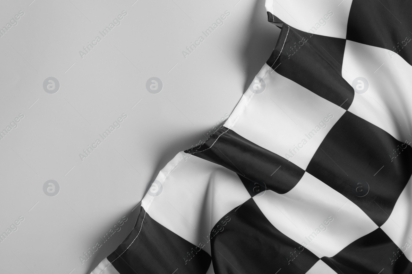 Photo of Checkered finish flag on white background, top view. Space for text