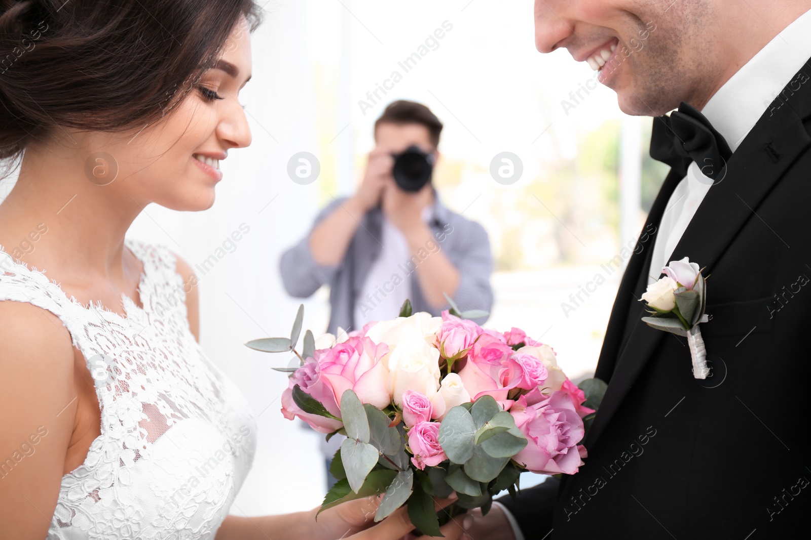 Photo of Professional photographer taking photo of wedding couple in studio