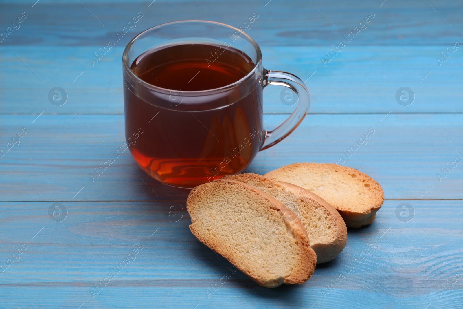 Photo of Hard chuck crackers and cup of tea on light blue wooden table