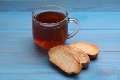 Photo of Hard chuck crackers and cup of tea on light blue wooden table