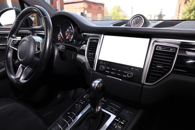 Photo of Steering wheel and dashboard inside of modern black car, closeup