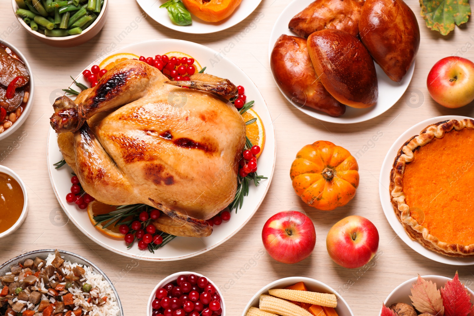 Photo of Traditional Thanksgiving day feast with delicious cooked turkey and other seasonal dishes served on wooden table, flat lay