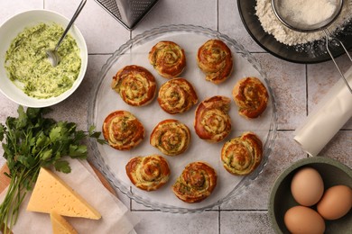 Photo of Fresh delicious puff pastry and ingredients on white tiled surface, flat lay