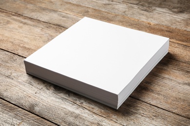 Photo of Stack of blank paper sheets for brochure on wooden background. Mock up