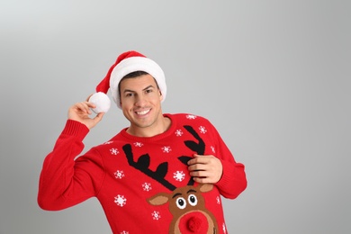 Photo of Handsome man wearing Santa hat on grey background