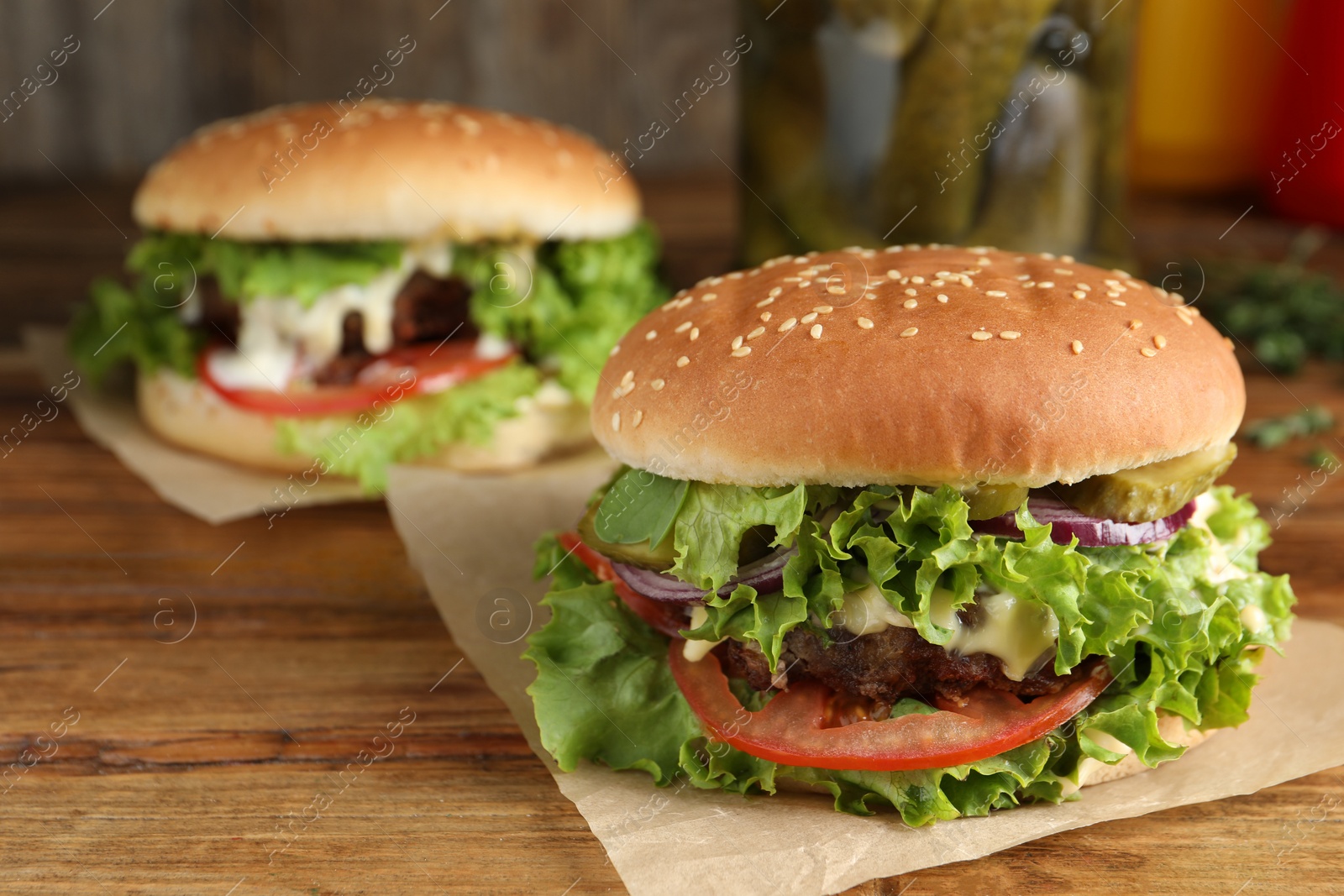 Photo of Delicious burgers with beef patty on wooden table, space for text