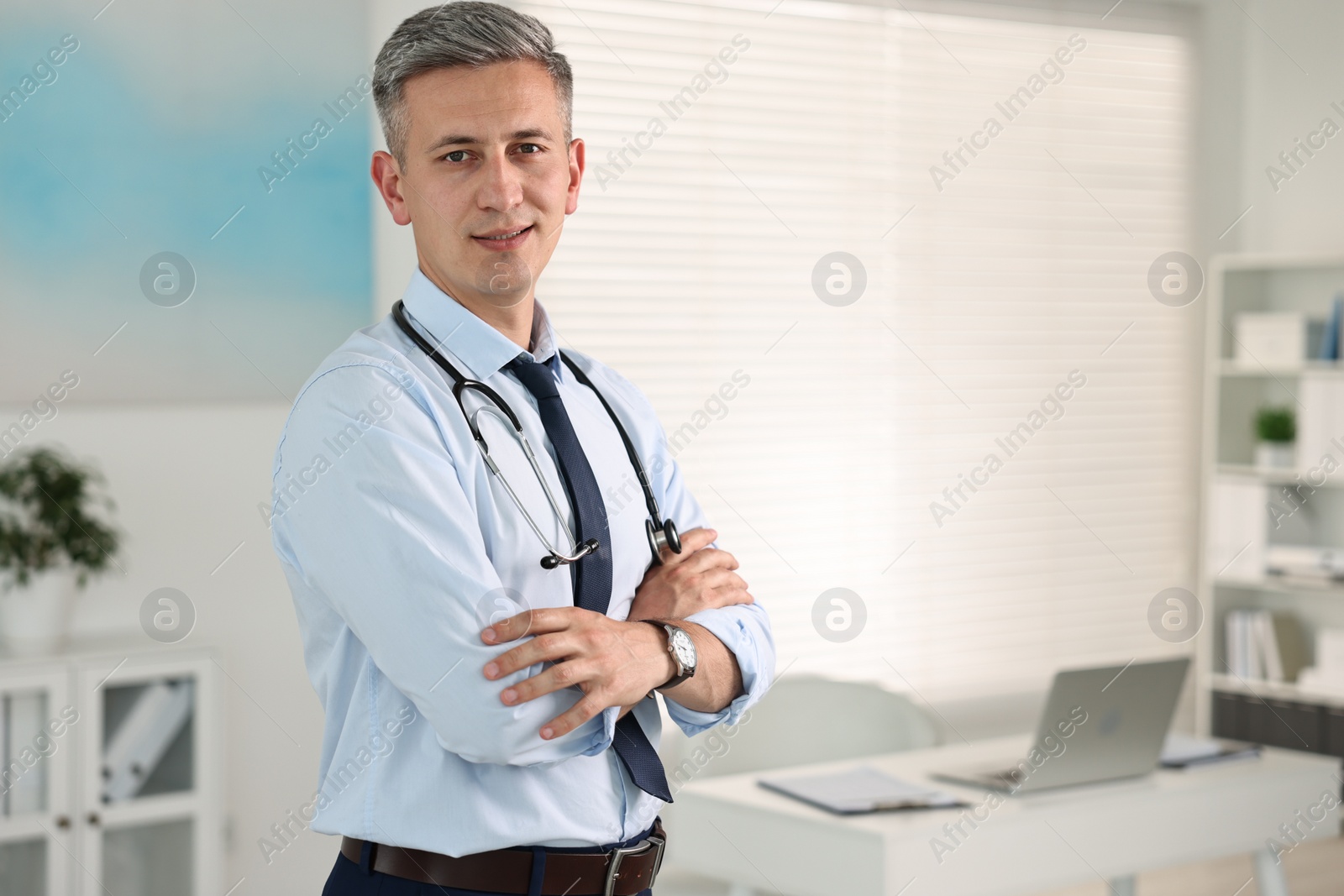 Photo of Portrait of doctor with stethoscope in clinic, space for text