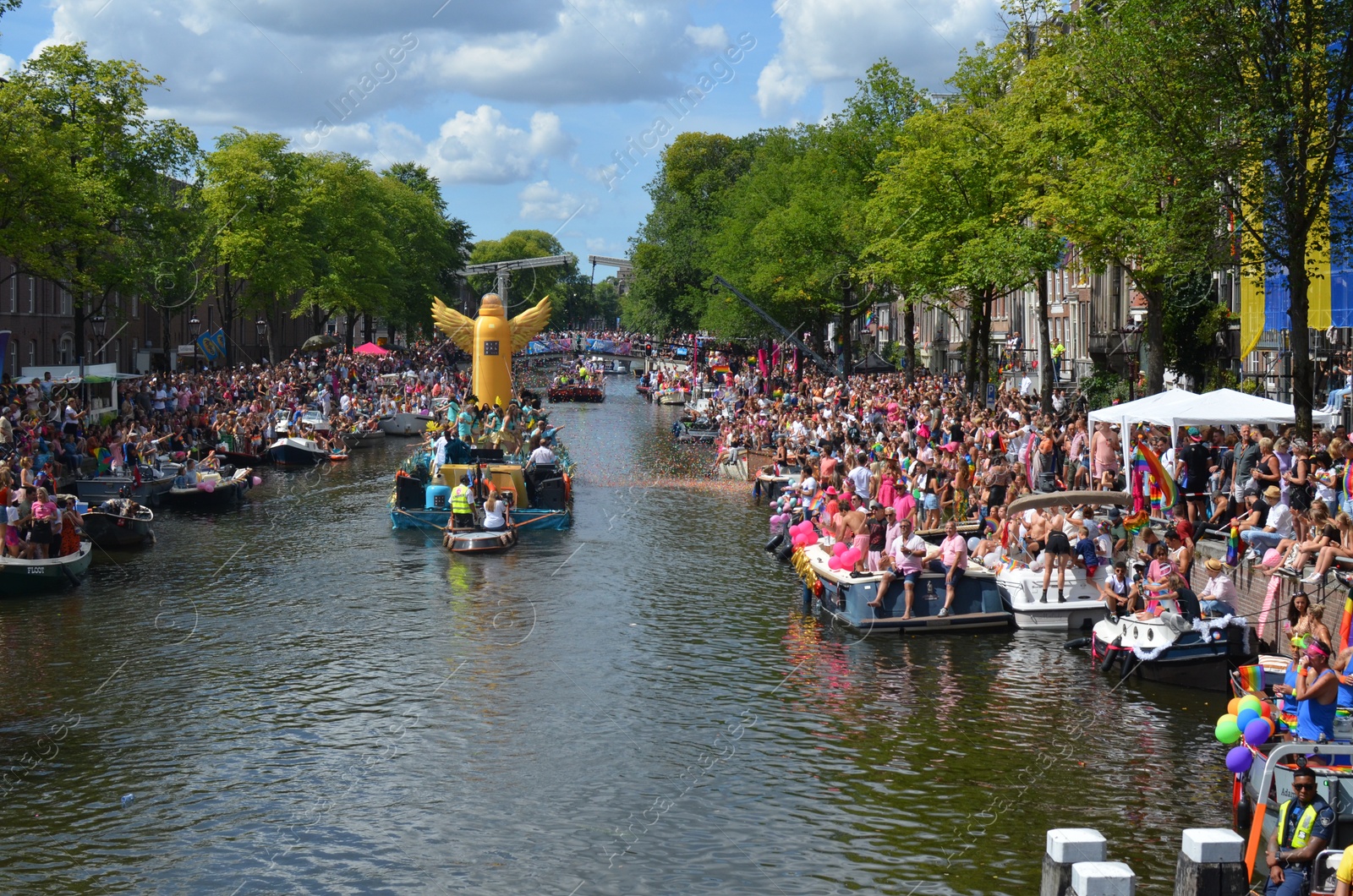 Photo of AMSTERDAM, NETHERLANDS - AUGUST 06, 2022: Many people in boats at LGBT pride parade on river