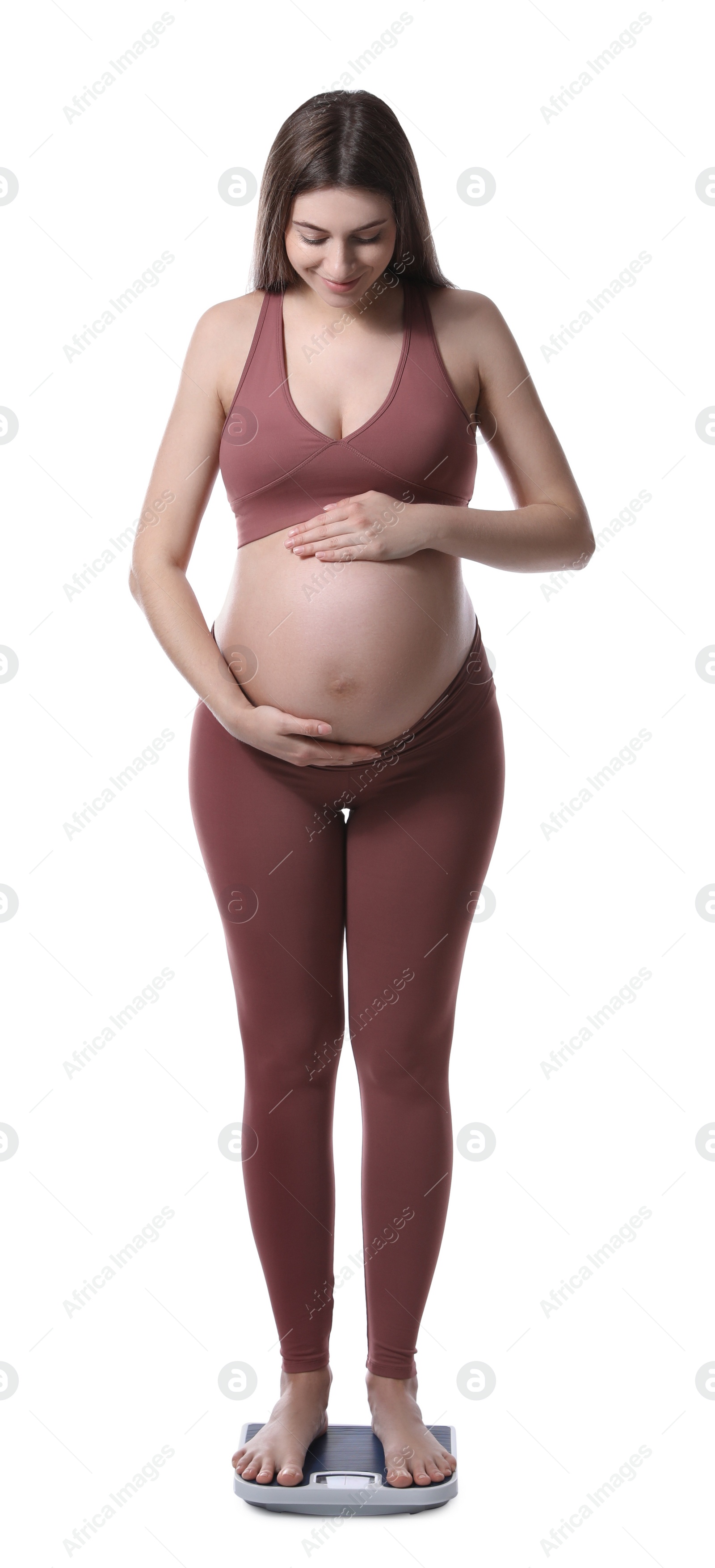 Photo of Pregnant woman standing on scales against white background