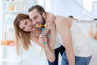 Young couple brushing teeth together in bathroom