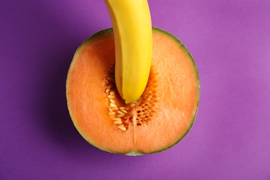 Photo of Flat lay composition with fresh banana and melon on purple background. Sex concept