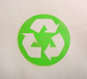 Photo of Recycling symbol on cardboard paper, top view
