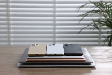 Photo of Many different modern gadgets on wooden table indoors. Space for text