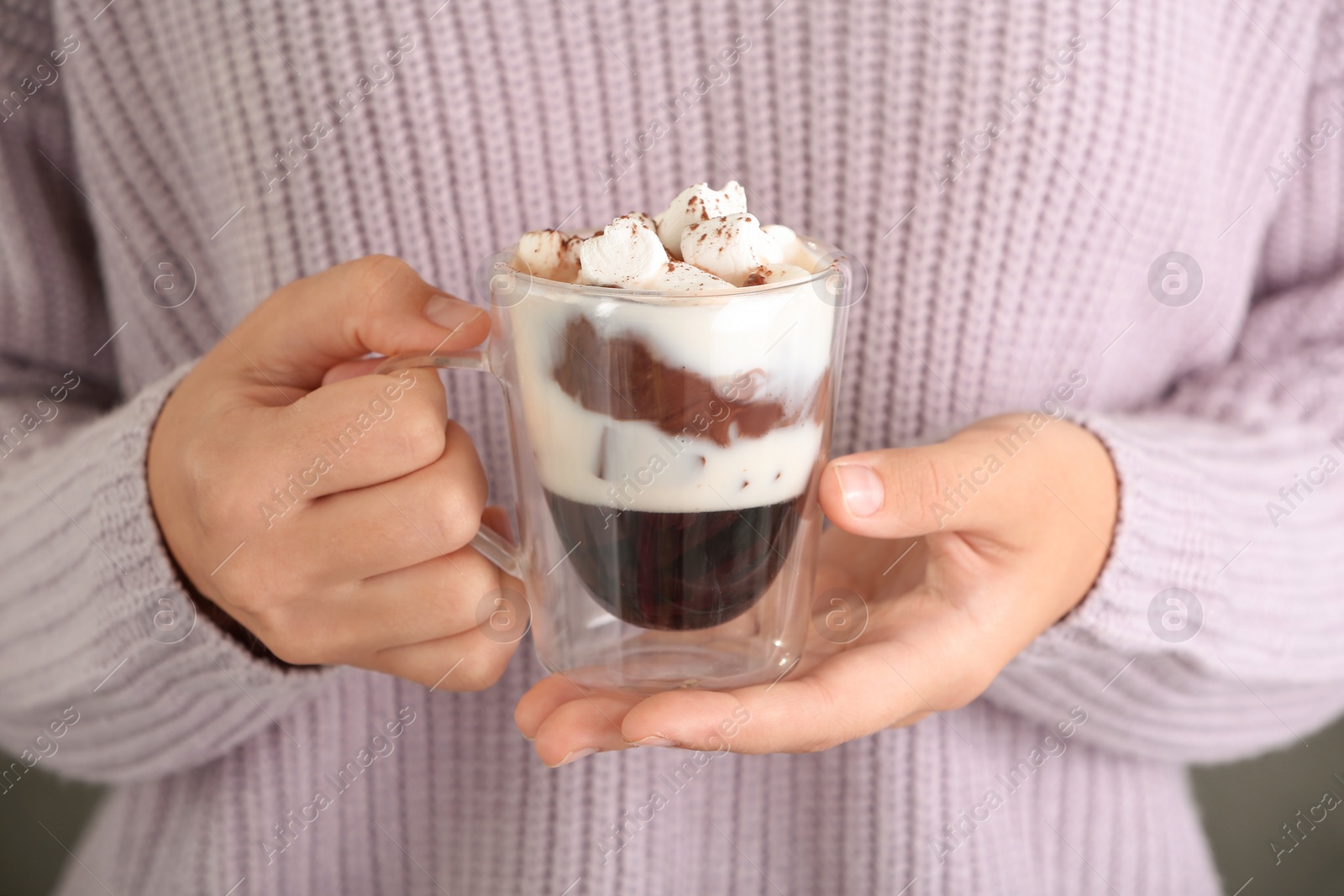 Photo of Woman holding chocolate dessert with marshmallows, closeup