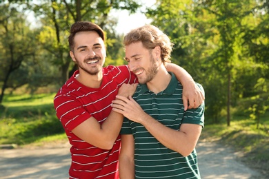 Portrait of happy gay couple smiling in park