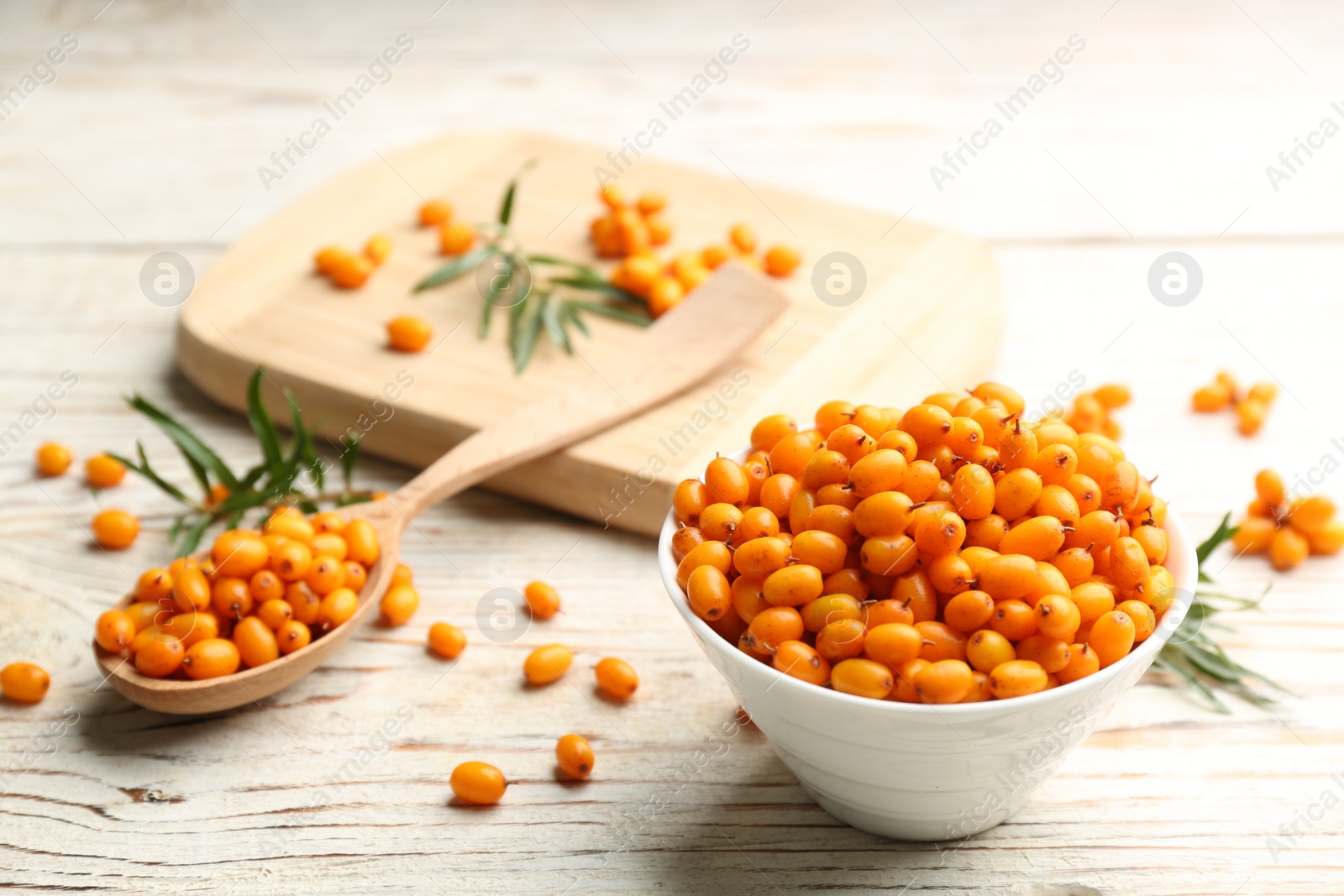 Photo of Fresh ripe sea buckthorn on white wooden table