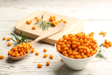 Photo of Fresh ripe sea buckthorn on white wooden table