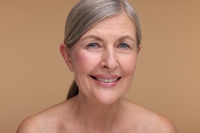 Photo of Portrait of beautiful mature woman on beige background