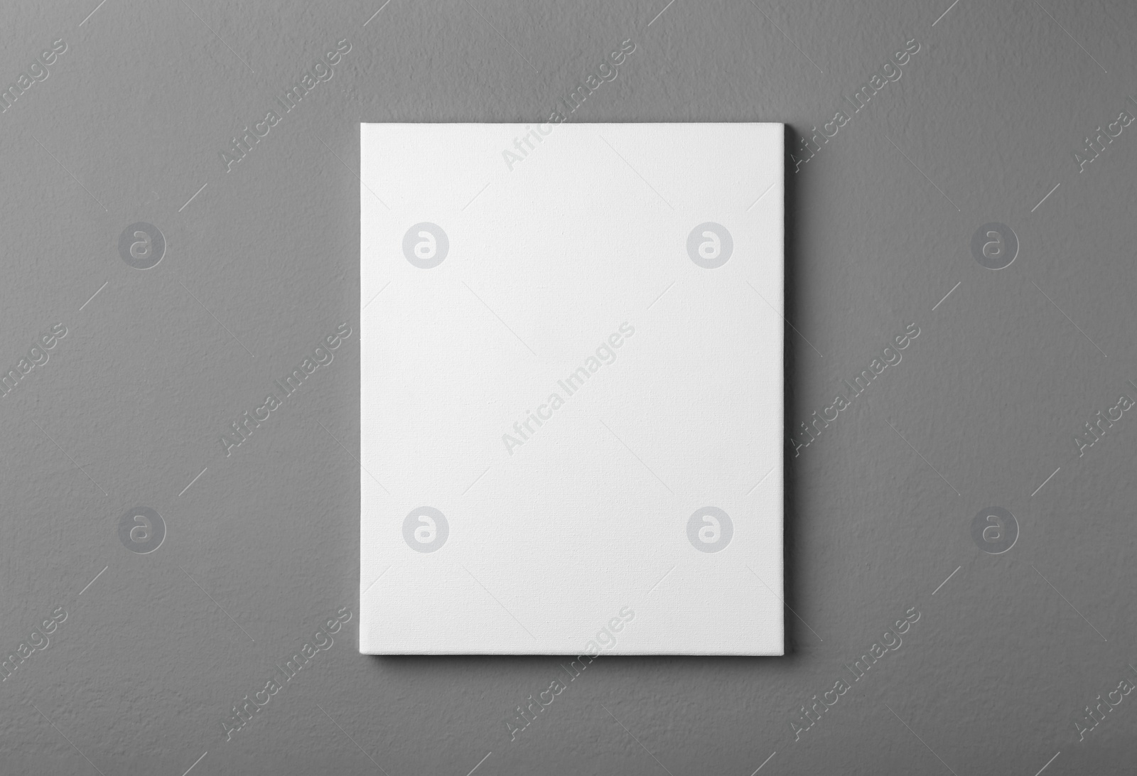 Photo of Blank canvas on grey wall. Space for design