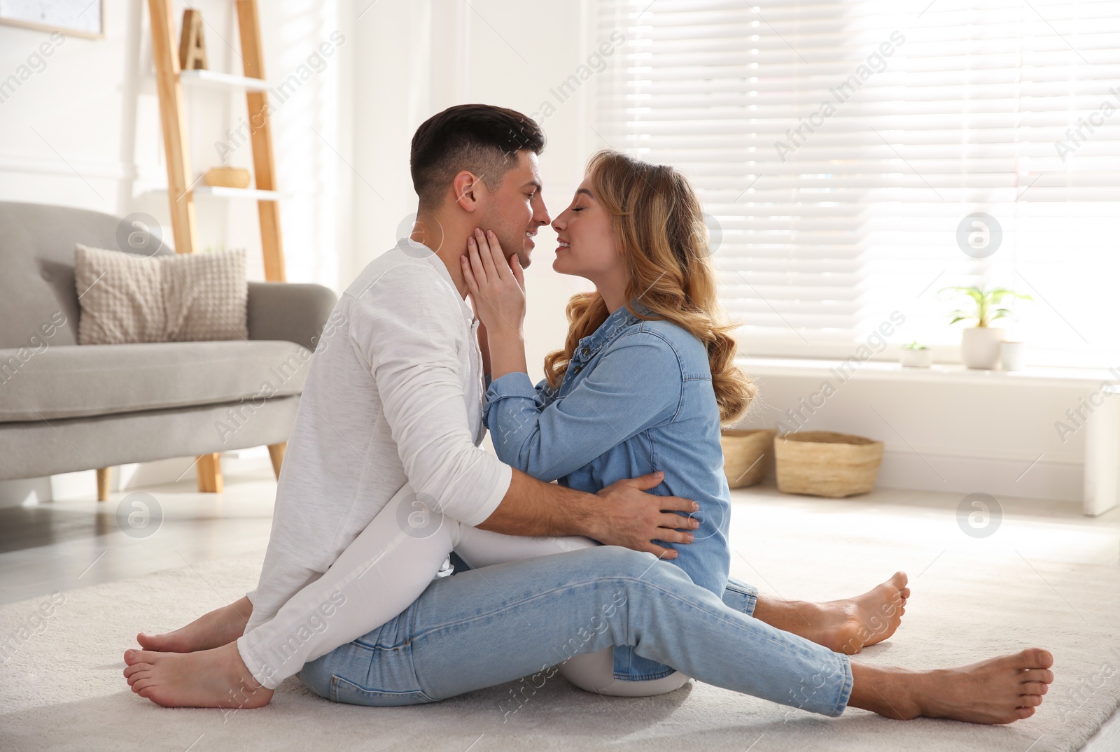 Photo of Lovely couple enjoying time together on floor in living room