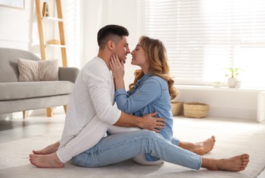 Lovely couple enjoying time together on floor in living room