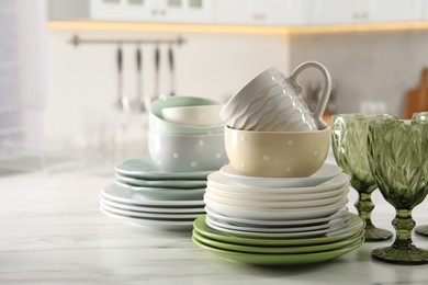 Photo of Many different clean dishware, glasses and cup on white marble table indoors. Space for text