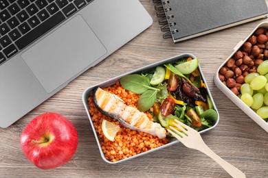 Photo of Healthy products high in vegetable fats near laptop on wooden table, flat lay