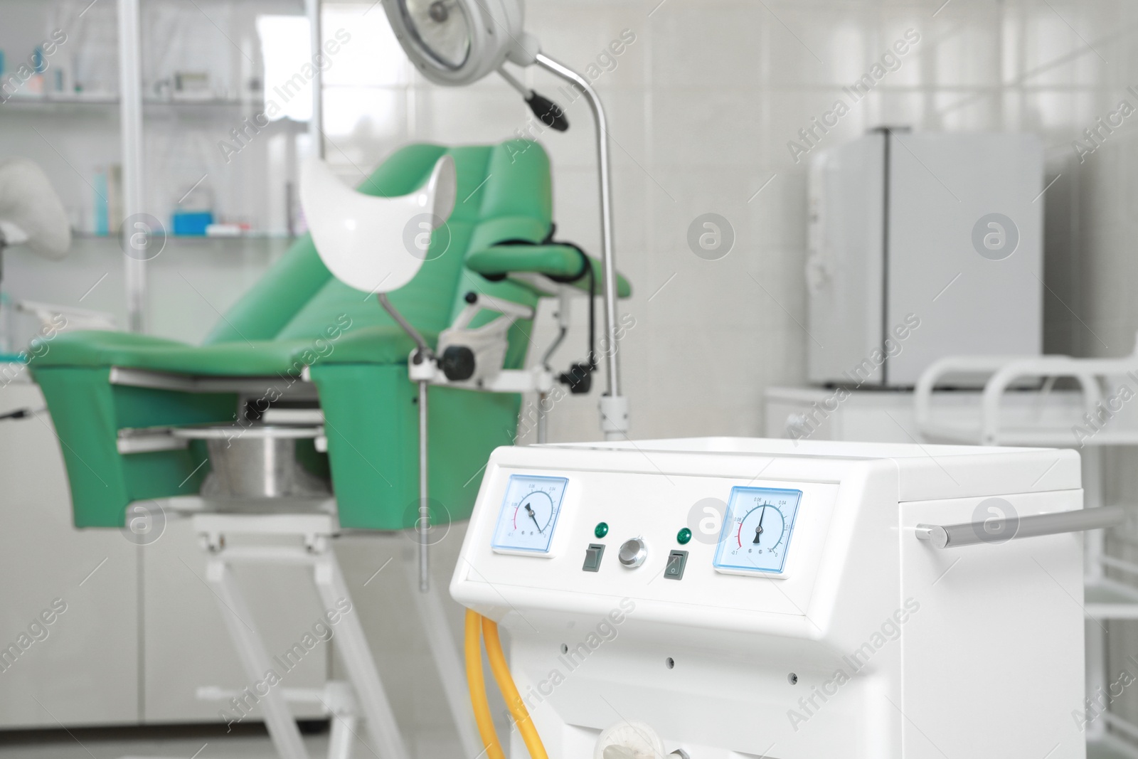 Photo of Examination room with medical aspirator for artificial abortion and gynecological chair in clinic, space for text