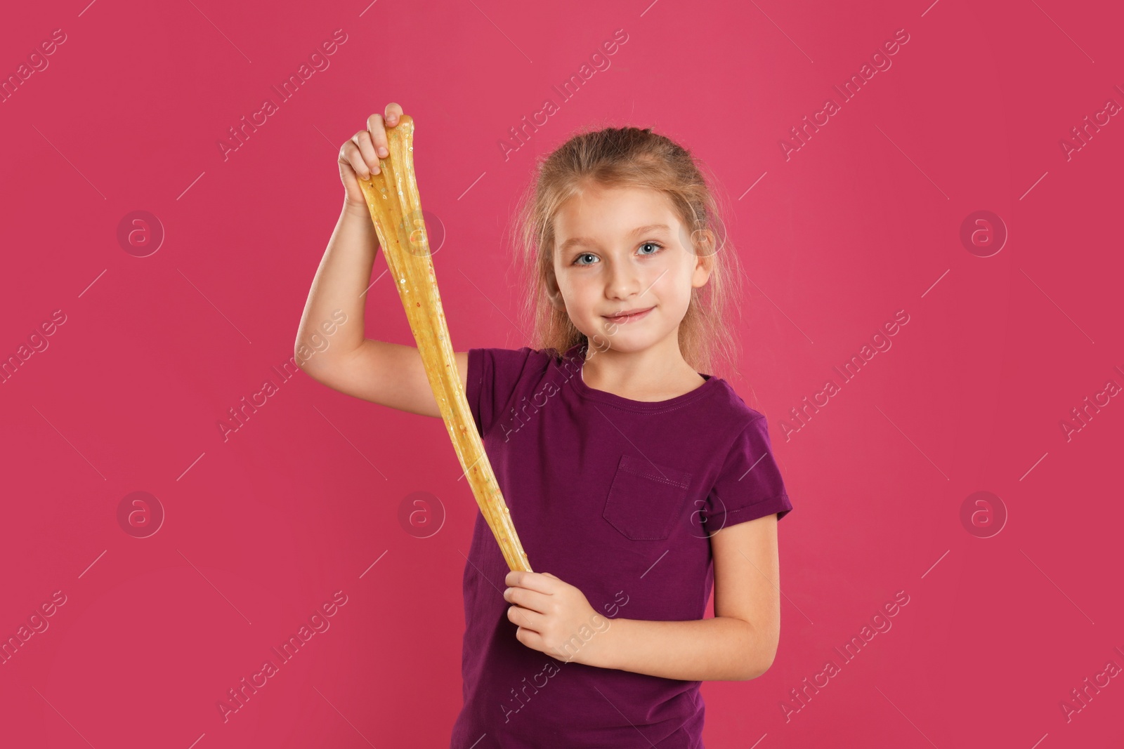 Photo of Little girl with slime on pink background