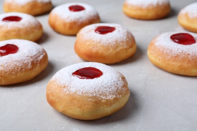 Photo of Hanukkah doughnuts with jelly and sugar powder on grey table