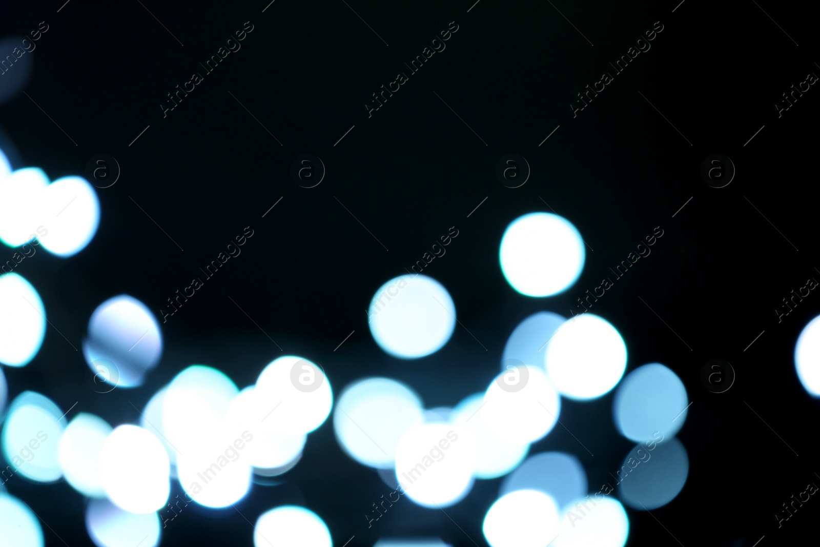 Photo of Blurred view of beautiful lights on black background. Bokeh effect