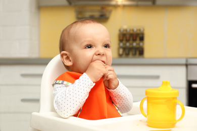 Cute little baby eating cookie at home