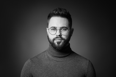 Photo of Portrait of handsome bearded man on dark background. Black and white effect