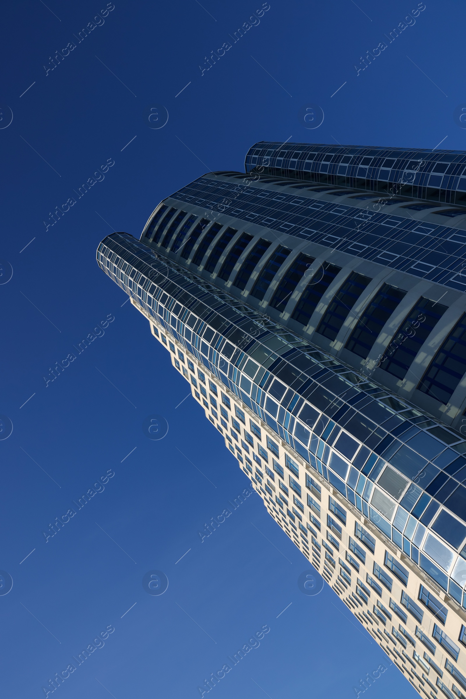 Photo of Beautiful skyscraper against blue sky on sunny day, low angle view